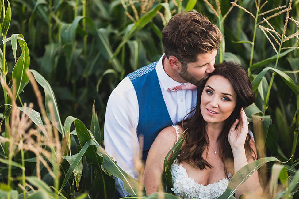 bride and groom in cornfield