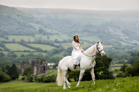 Boho farm wedding Wales - Bride arrives on white horse